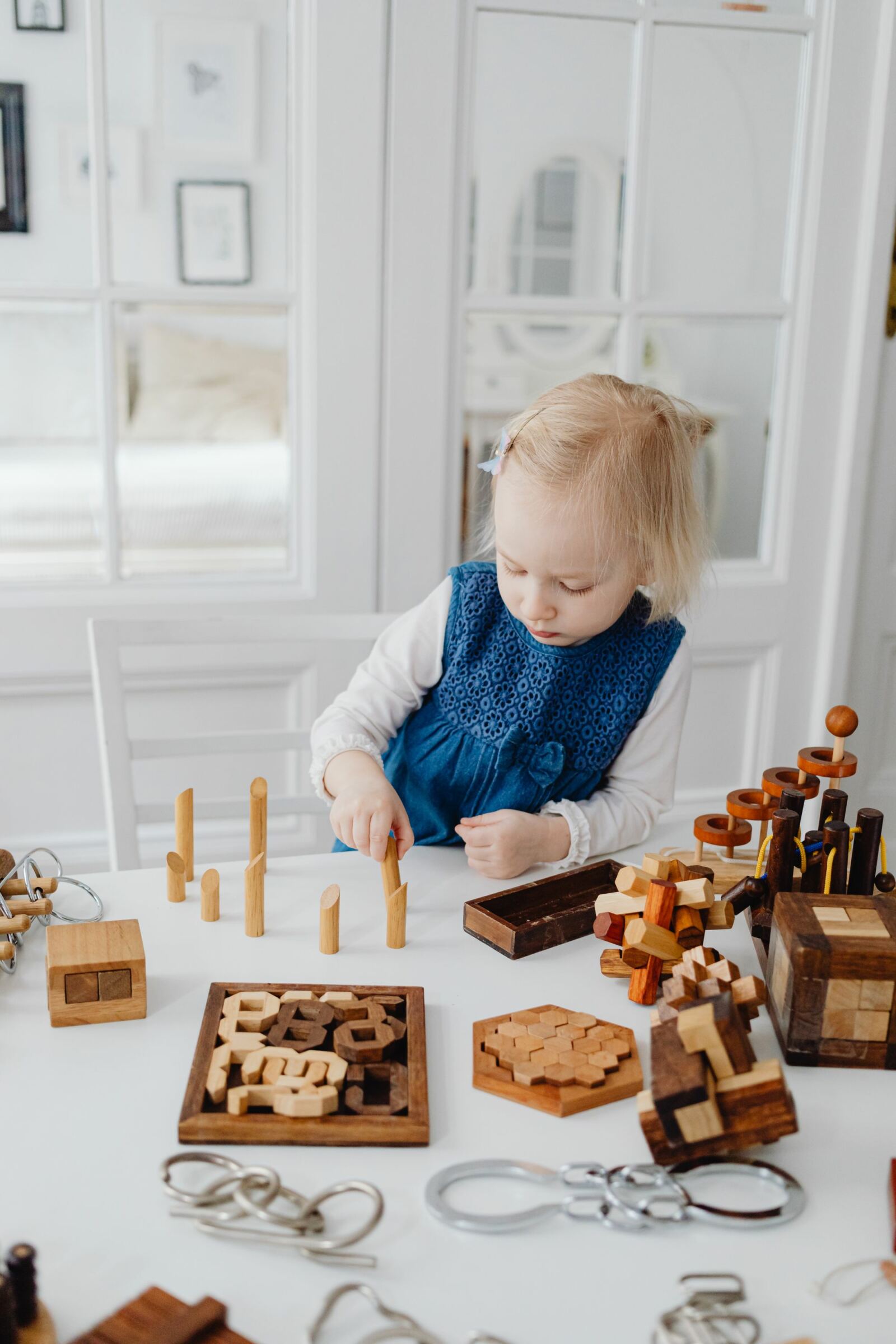 Jeune enfant absorbé par des puzzles et casse-têtes en bois sur une table