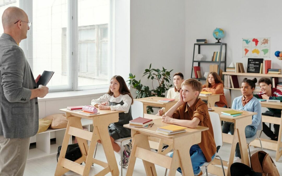 Enseignant debout face à sa classe pendant une leçon, phase de modelage de l'enseignement explicite