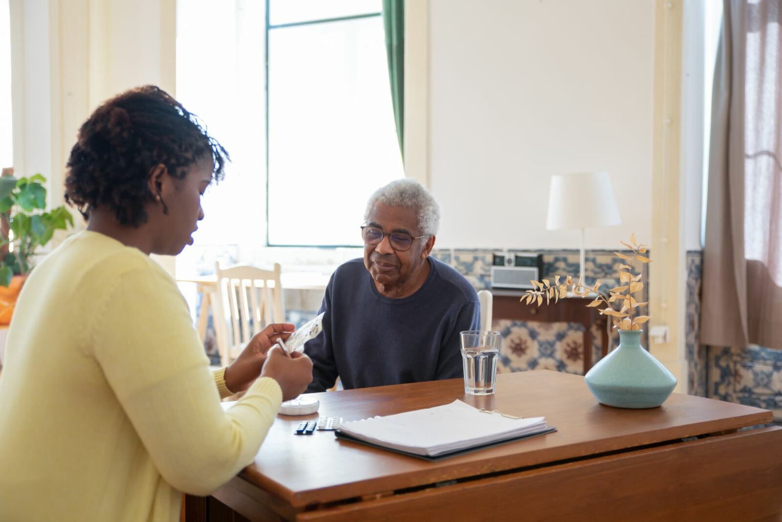 Professionnelle et homme âgé travaillant ensemble à une table, activité d’organisation
