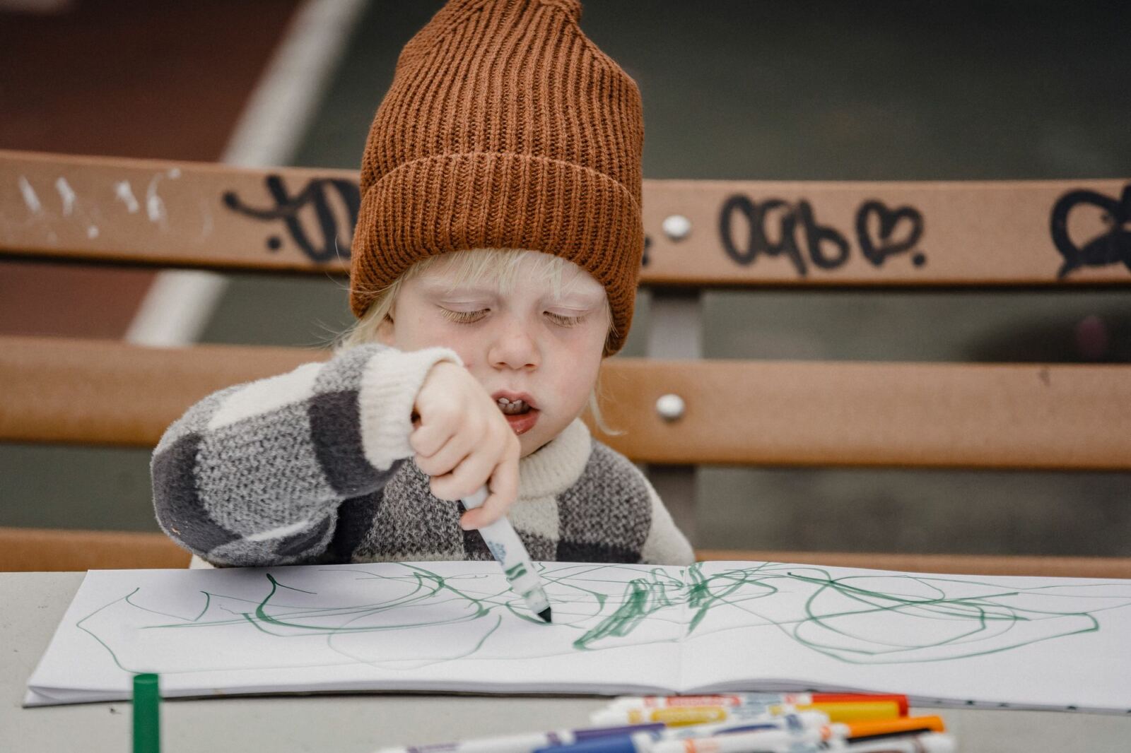Jeune enfant dessinant avec application, feutre serré dans la main