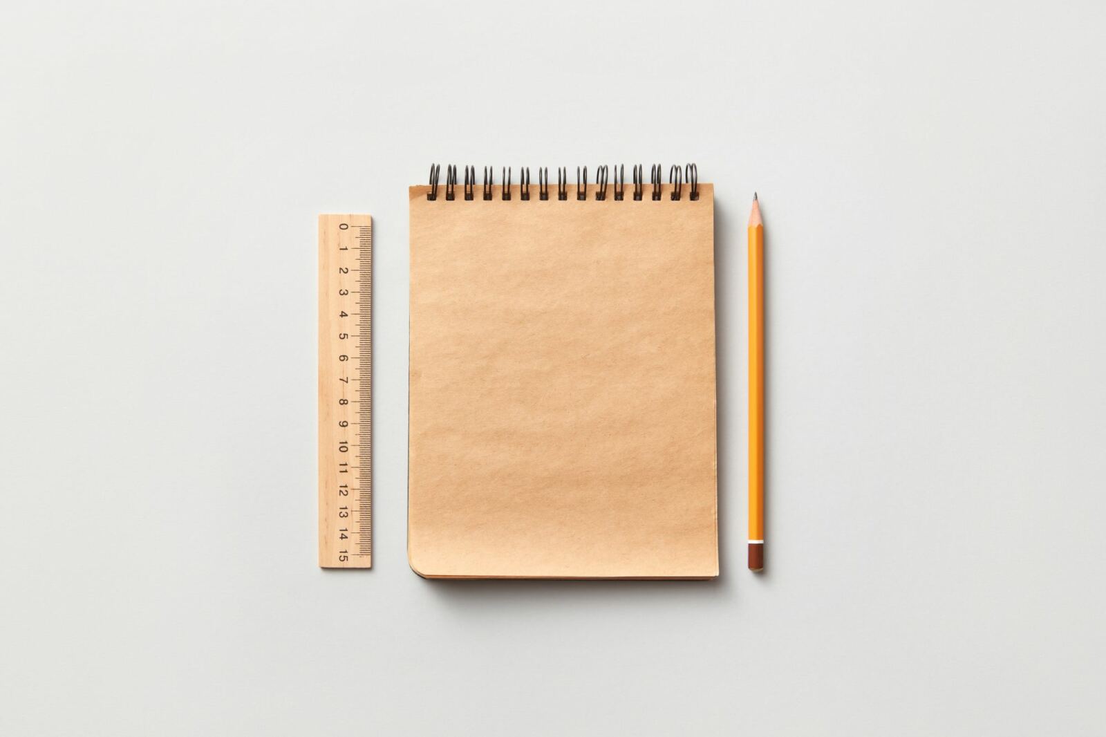 Carnet, règle et crayon posés sur un bureau clair, outils de travail en séance