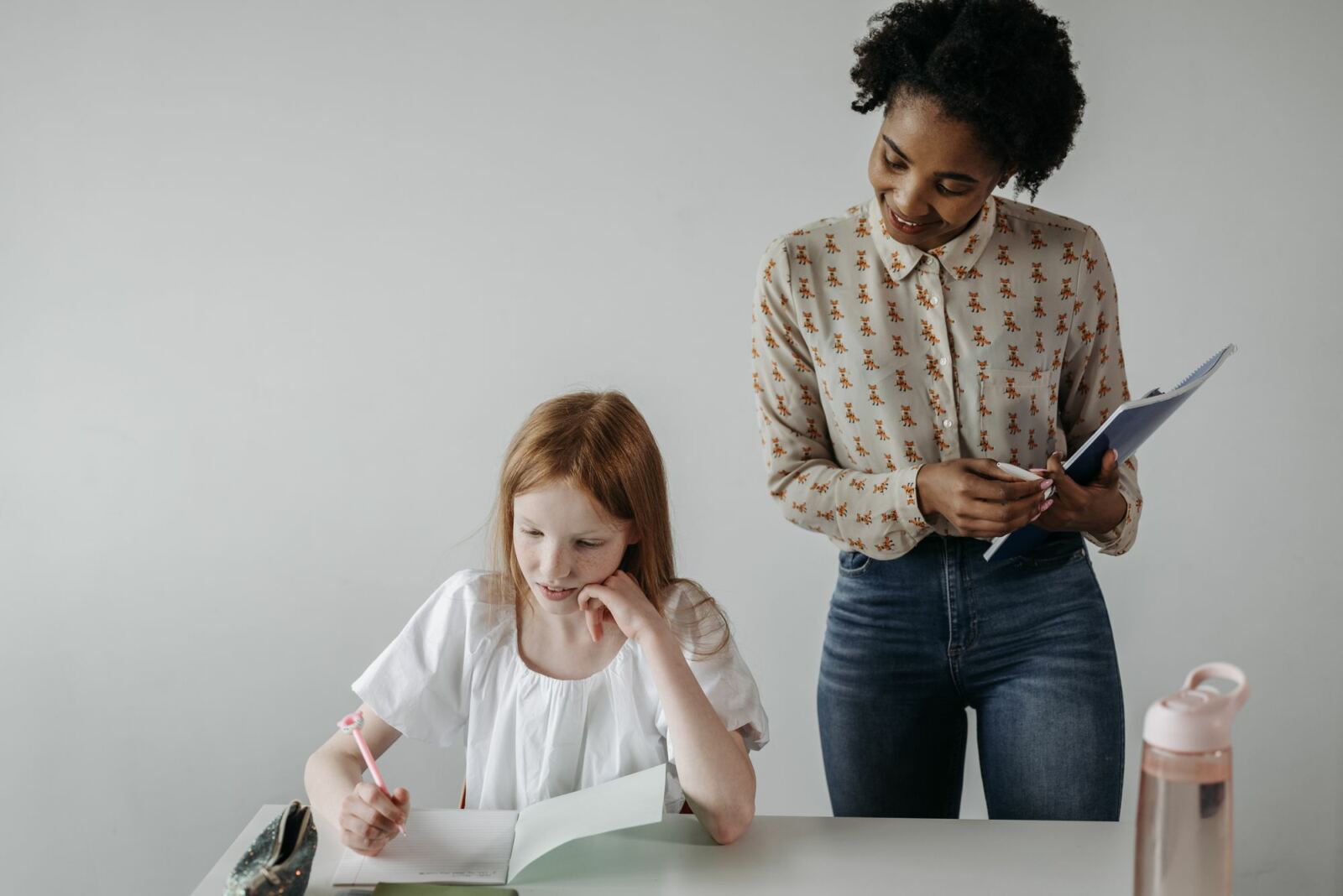 Praticienne accompagnant une élève qui écrit, en séance individuelle